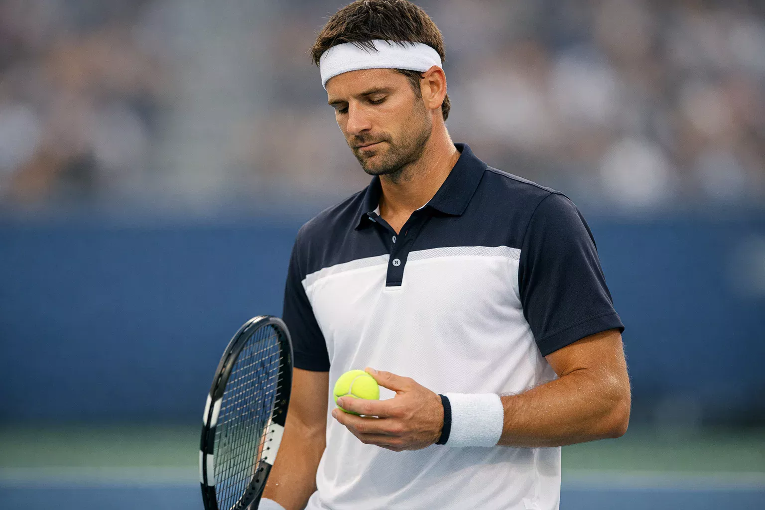 Tennisspieler mit konzentriertem, ruhigem Gesichtsausdruck vor dem Aufschlag