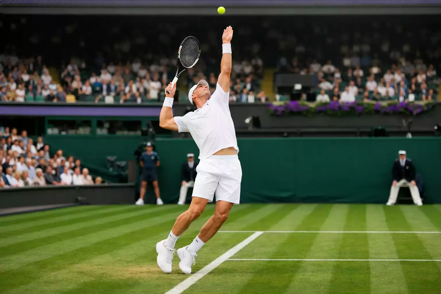 Tennisspieler serviert auf dem grünen Rasen des Wimbledon Centre Court
